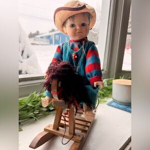 Doll in Striped Outfit on Rocking Horse